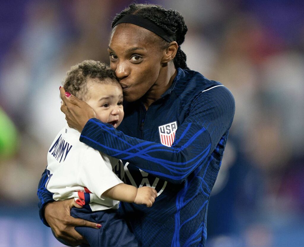 Chrystal Dunn, Elite Postpartum Female Football Player, embracing her child